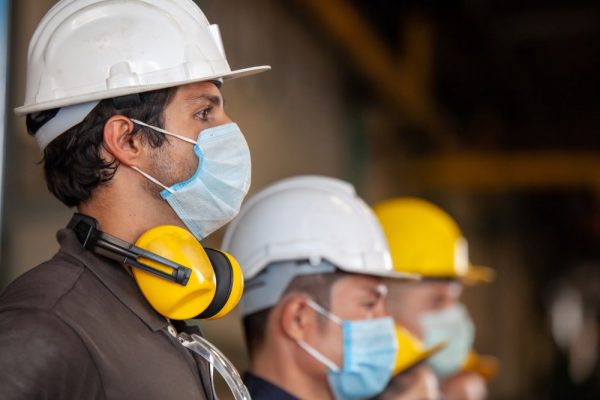 uomini con casco e mascherina al lavoro